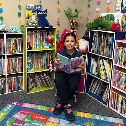 A girl sitting in a chair surrounded by books